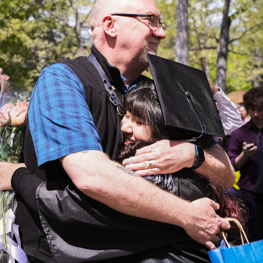 Stephen John embracing a graduating student